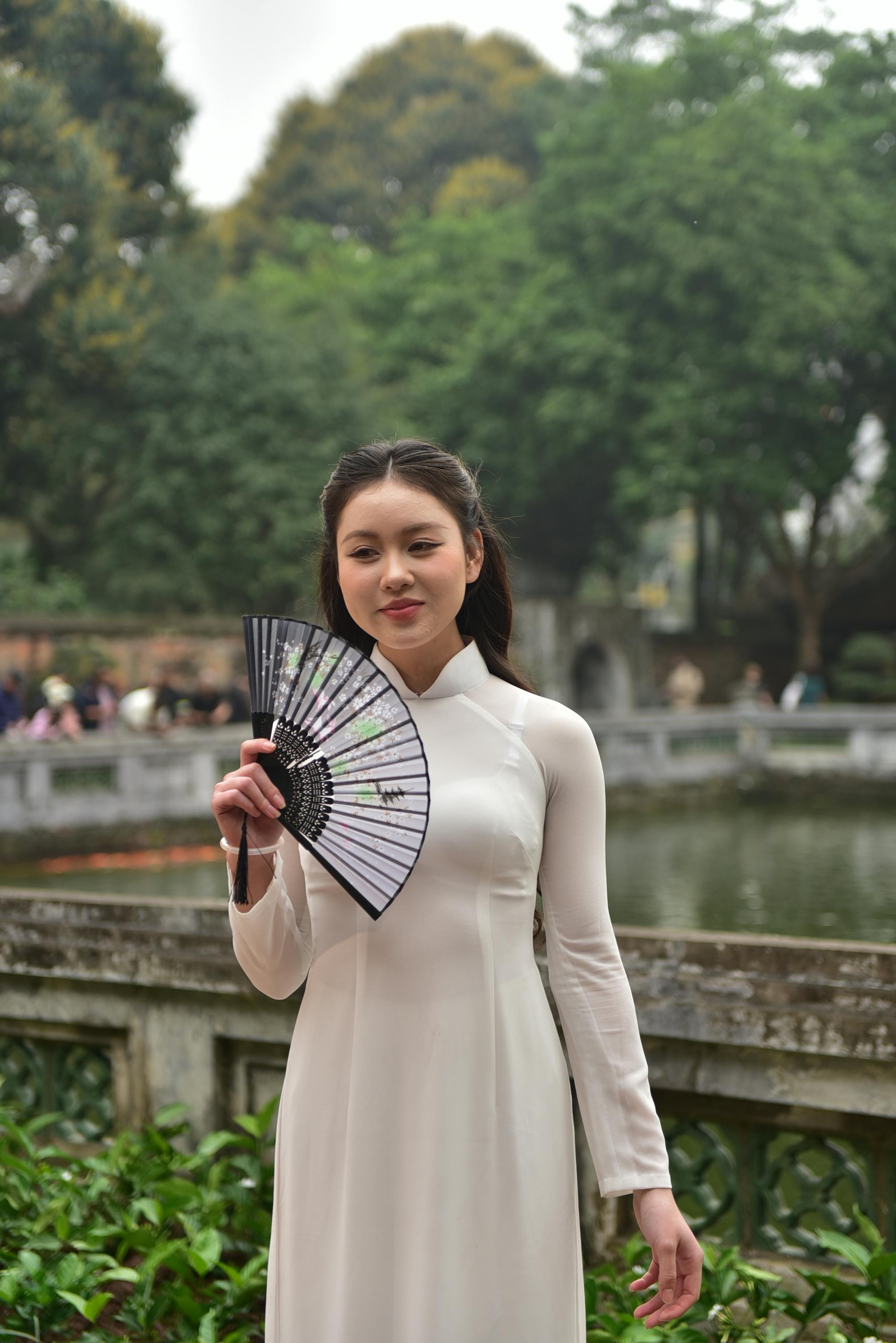 美景图片山水_寺庙中身着传统奥黛的年轻女子