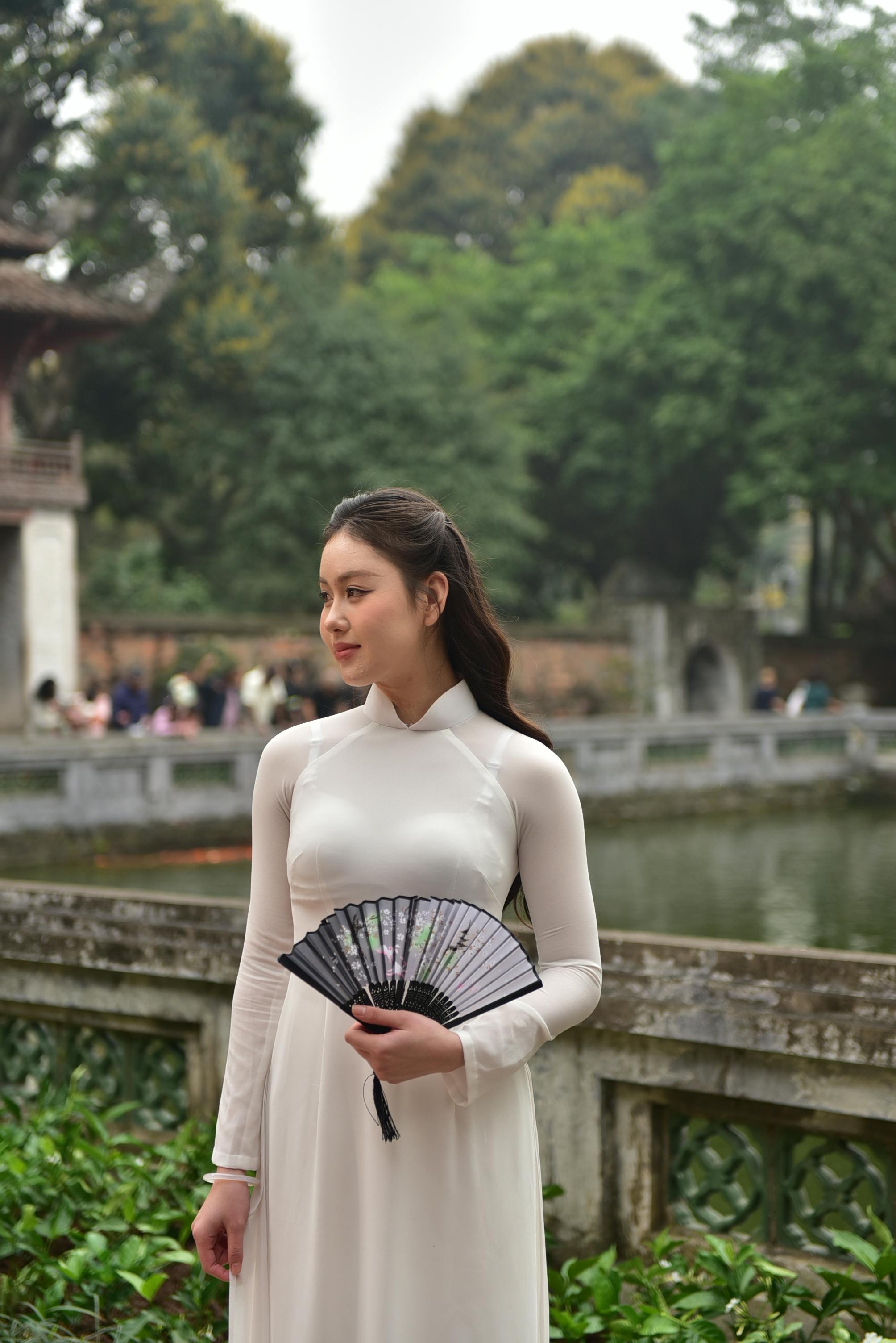 美景图片中国风景_户外穿着传统奥黛的年轻女子
