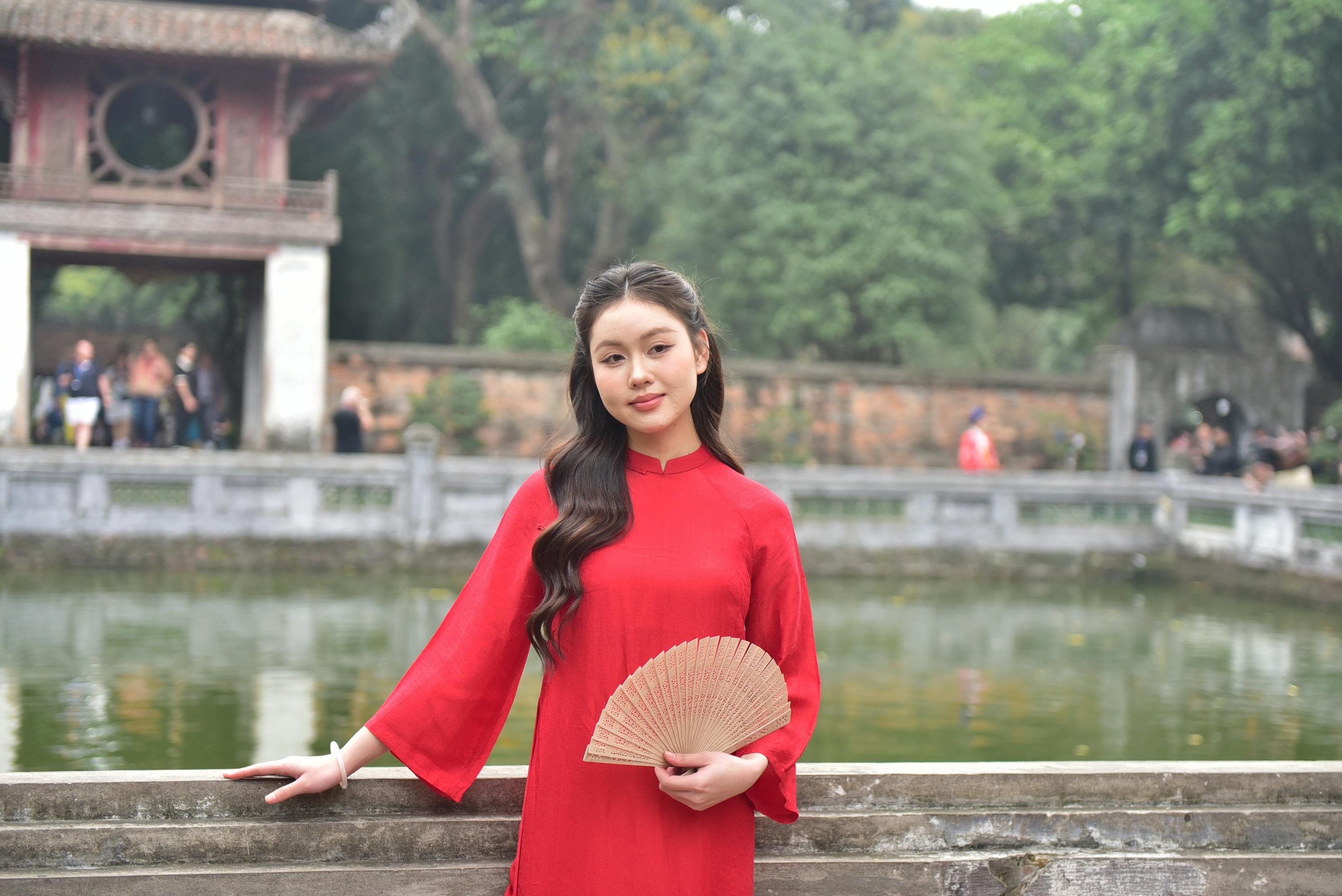 美景图片海岛_身穿红衣、手持扇子的越南女子