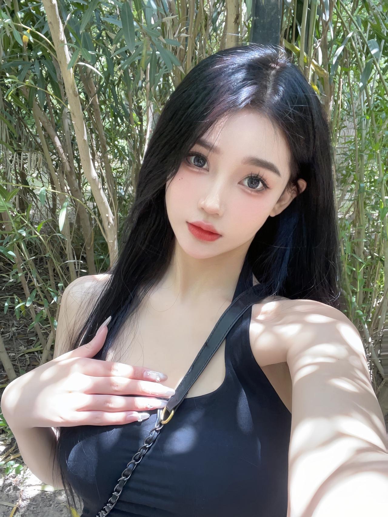 户外场景中欧美模特拿着手机手机要给出完整背面微笑活泼手指纹理清晰背景是蓝天白云与繁花盛开的玫瑰花阳光明媚_美女头像真人微信
