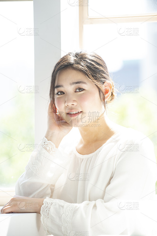 美丽的女孩与自然的头发在优雅的服装摆姿势在花苑_美女高雅造型