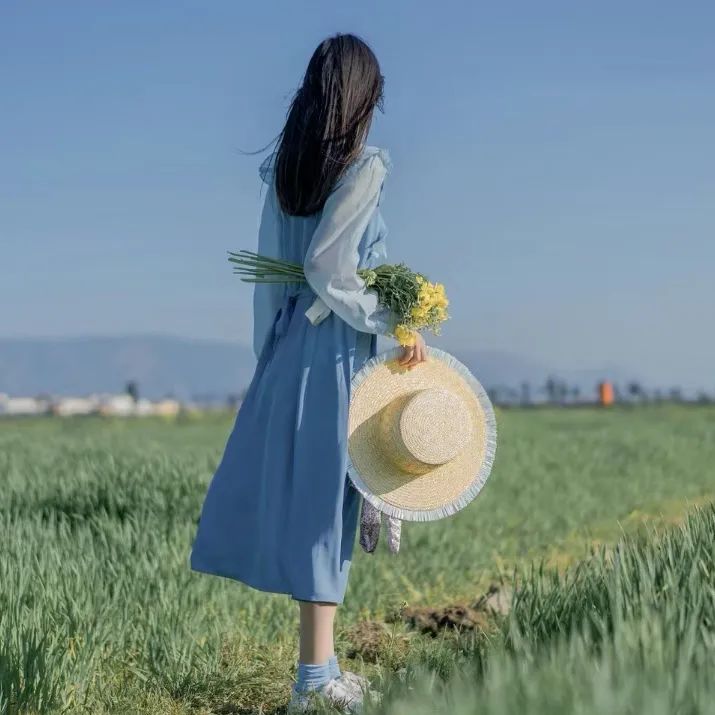美丽的女人在白色的裙子摆姿势在紫色的马鞭草花田迷人的中国女孩与黑色的长发享受她的休闲时间户外_美女头像真人职业